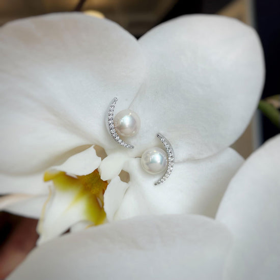 Photo of Half Moon Diamond Pearl Studs in a decorative scene, designed by , available at Plumb Gold & Plumb Silver