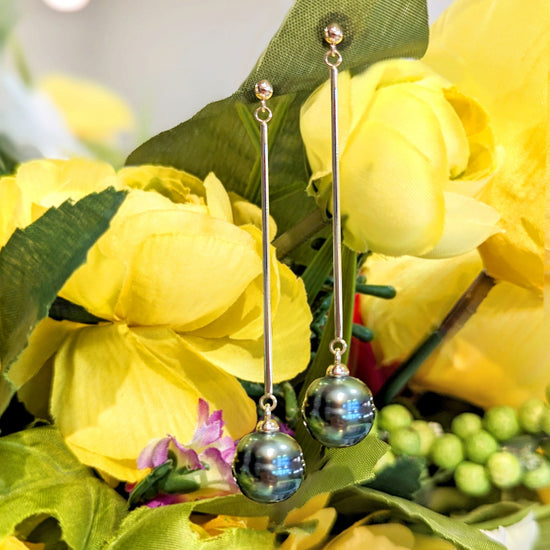 Photo of Tahitian Pearl Long Drop Earrings in a decorative scene, designed by , available at Plumb Gold & Plumb Silver