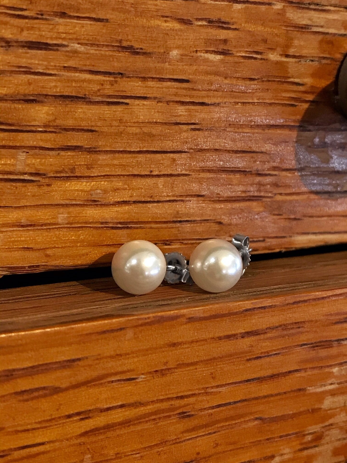 Photo of Zoma Color Akoya Pearl Studs in a decorative scene, designed by , available at Plumb Gold & Plumb Silver