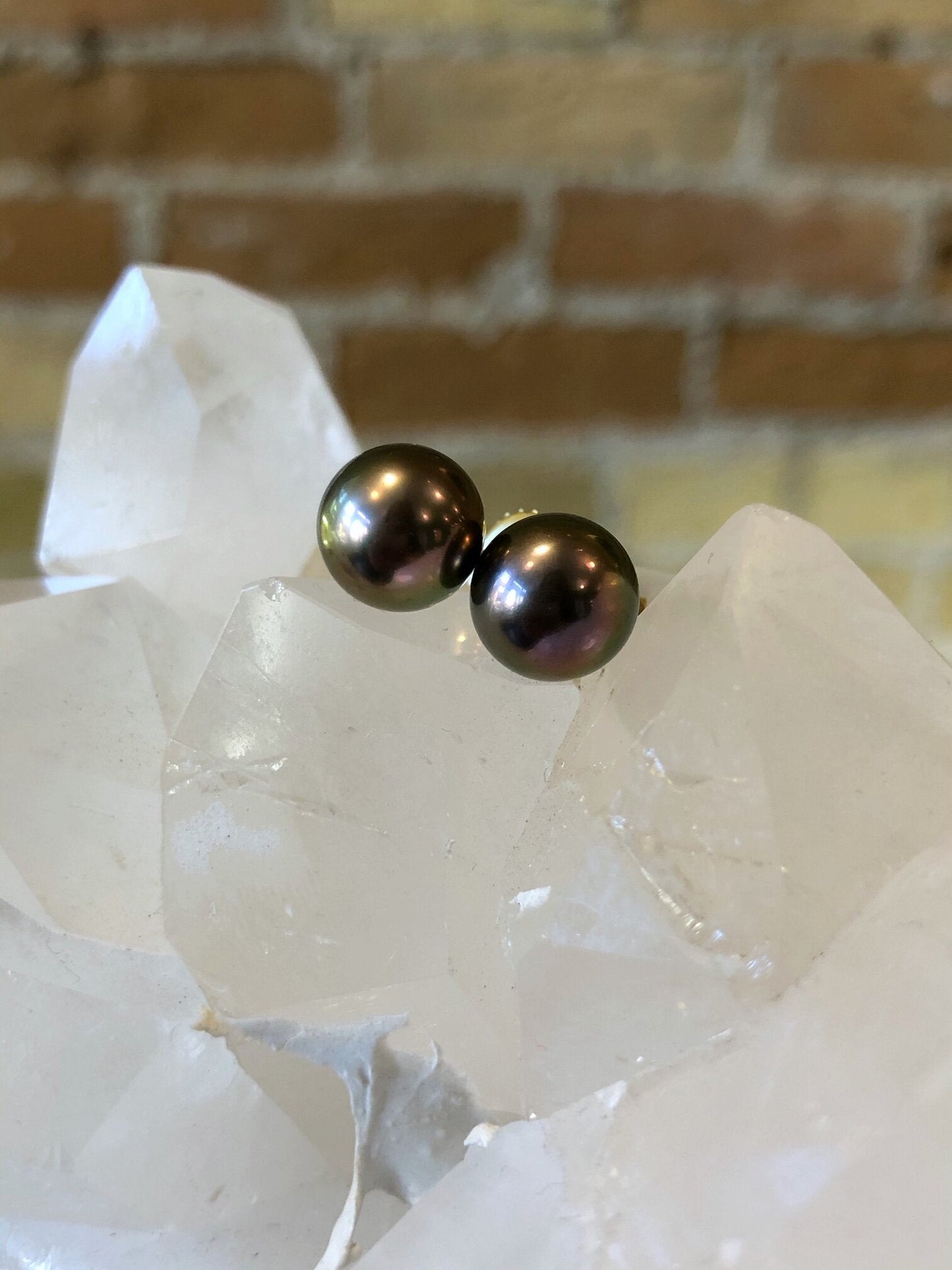 Photo of Zoma Color Tahitian Pearl Studs in a decorative scene, designed by , available at Plumb Gold & Plumb Silver