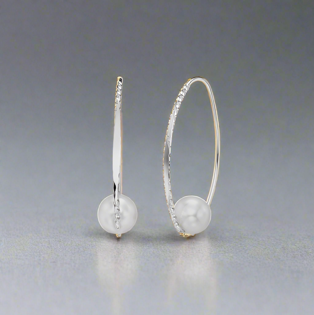 Earring standing upright on a reflective surface with a gray backdrop, available at plumb silver jewelry store